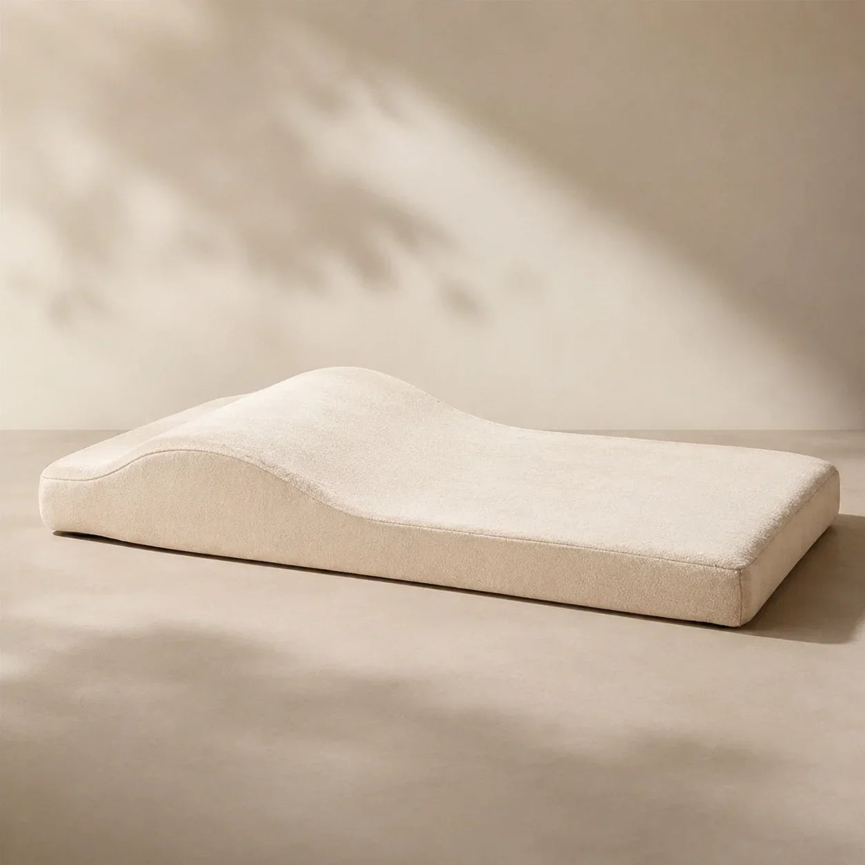 Cream orthopedic dog bed on a warm neutral floor